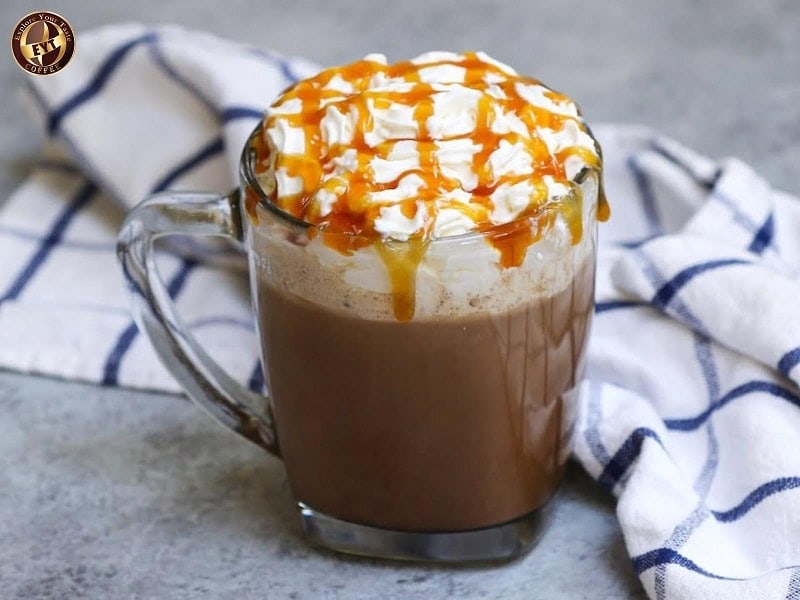 Người pha cà phê sữa đá mịn, kem tươi và sốt caramel trên ly thủy tinh, phục vụ tại EYT Coffee, quán cà phê nổi tiếng ở Việt Nam.